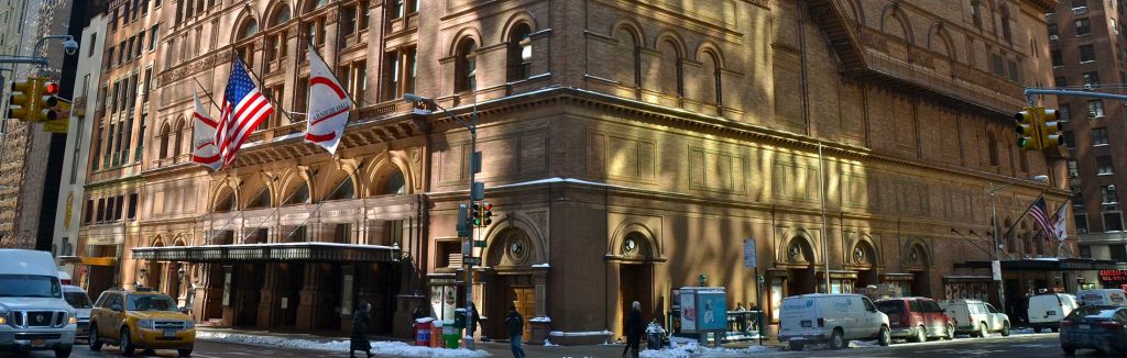Carnegie Concert Hall in Manhattan, New York with snow on the sidewalk and cars on the streets, carnegie hall performance tours