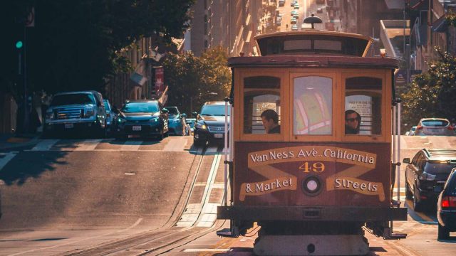 People riding inside a cable car on the busy San Francisco, California roads