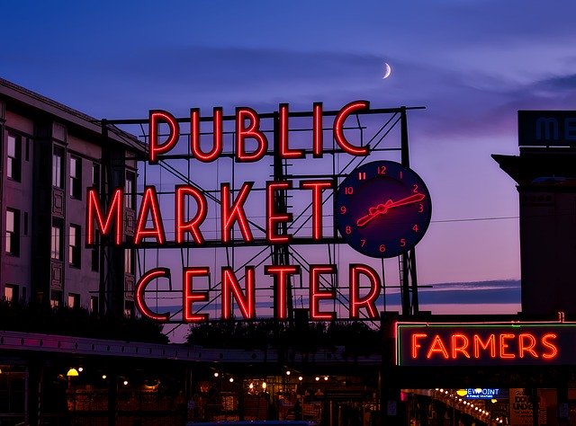 Seattle Park Place's red Market Public Market Center sign lit up against a purple and pink sunset